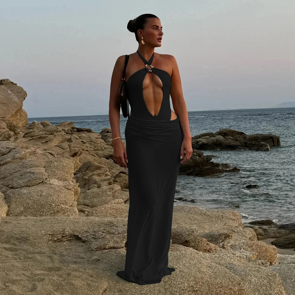Black monochrome one-piece swimsuit with maxi skirt on rocky beach