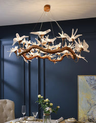Decorative chandelier hanging in a room with a blue wall and table setting.