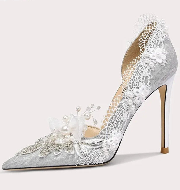 High-heeled shoe with lace and pearl details on a white background