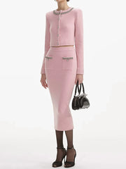 Person wearing a pink outfit with a matching handbag on a white background