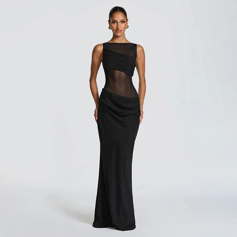 Woman wearing a black evening gown with sheer top on a white background