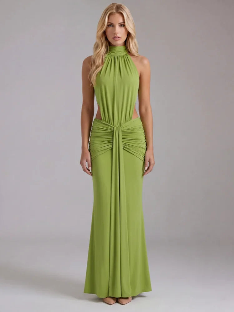 Studio shot of a woman in a green halter neck draped maxi dress.
