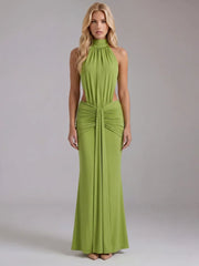 Studio shot of a woman in a green halter neck draped maxi dress.