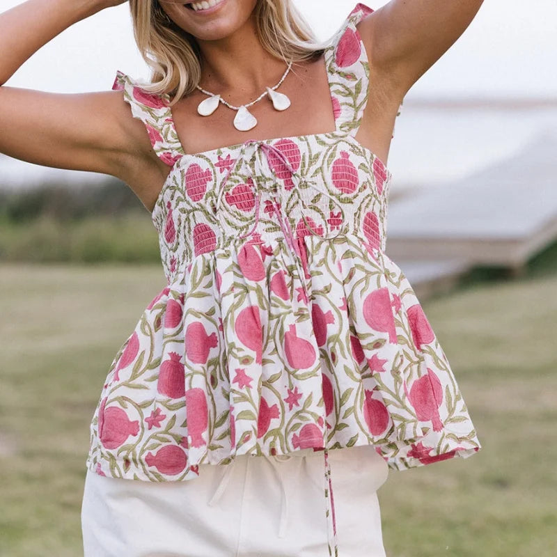 Woman wearing a floral top with pink and green pattern outdoors