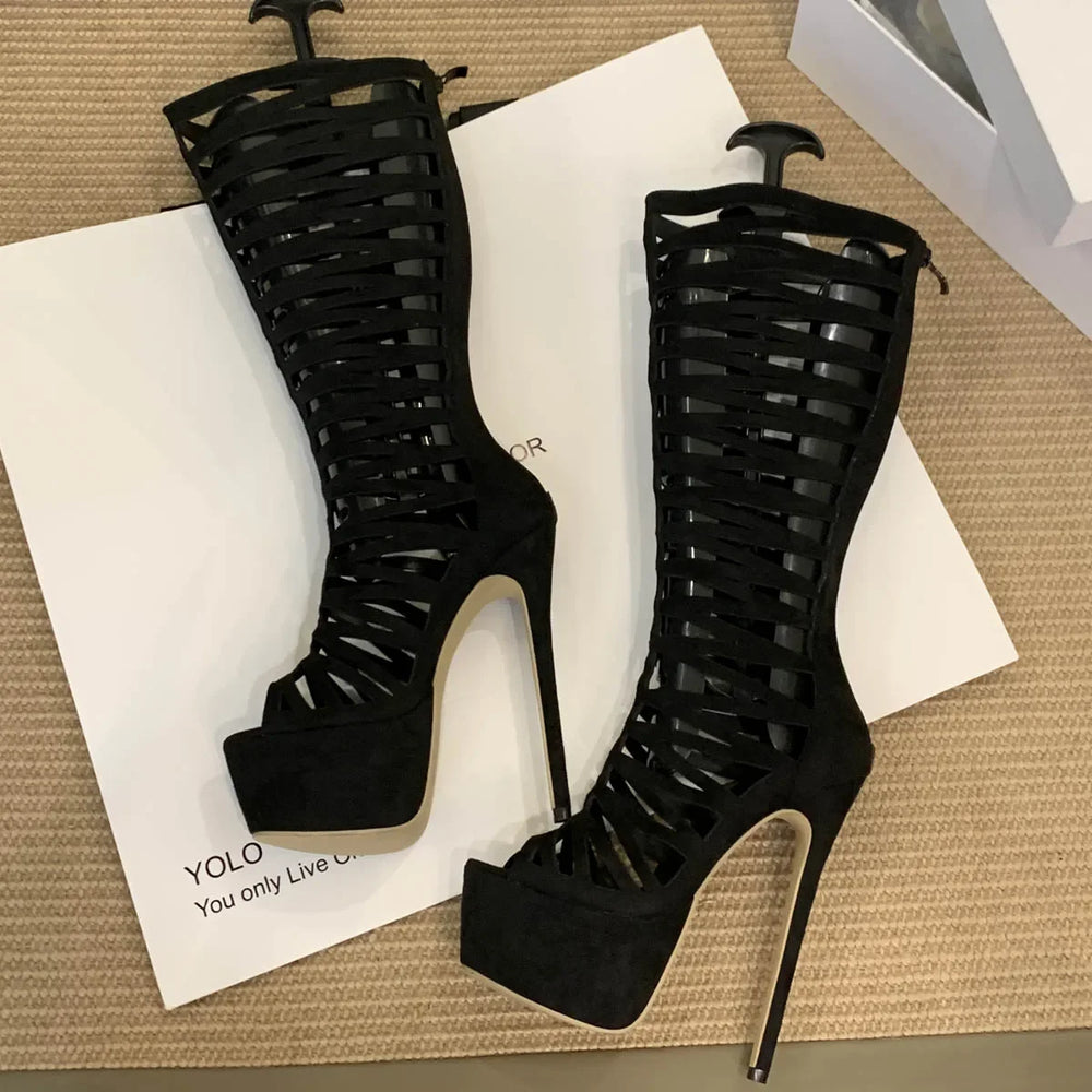 Black high-heeled sandals with open-toe design on a beige surface.