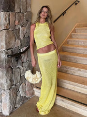 Woman in a yellow outfit standing on a staircase next to a stone wall.
