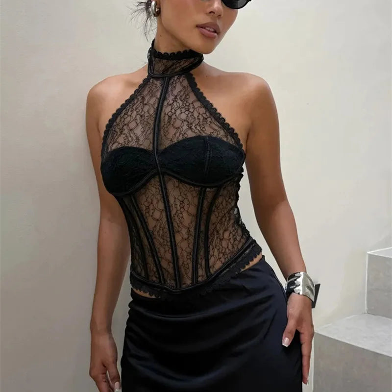 Woman wearing a black lace halter top and skirt against a plain background