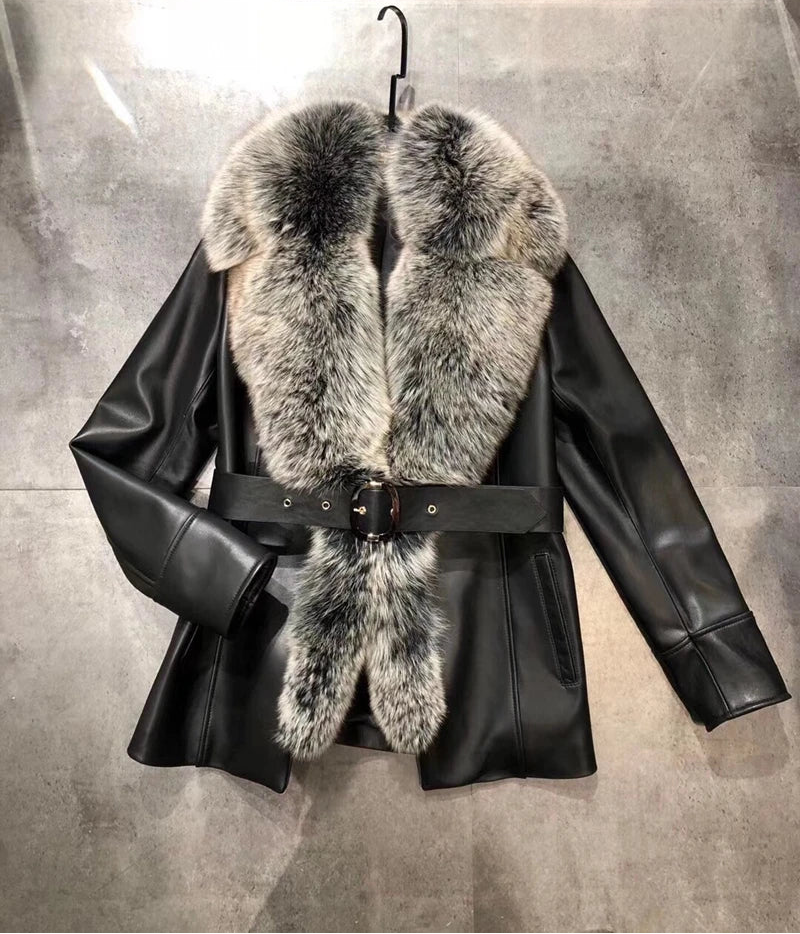 Black leather jacket with fur collar on a gray background