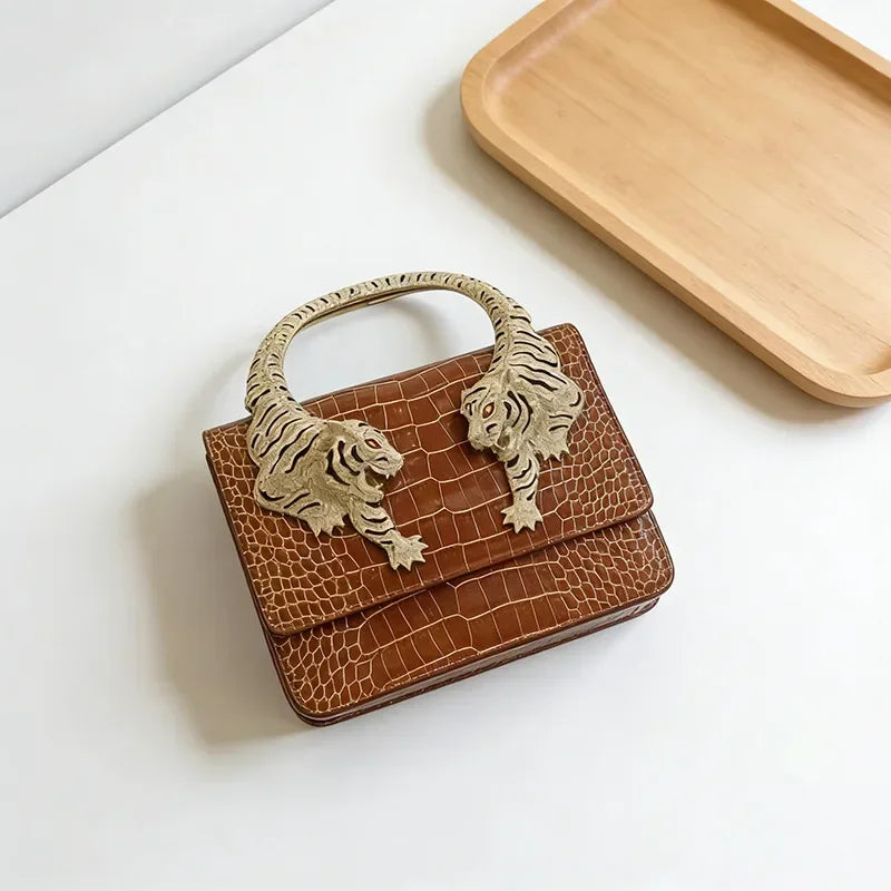 Brown embossed leather handbag with sculpted tiger handle