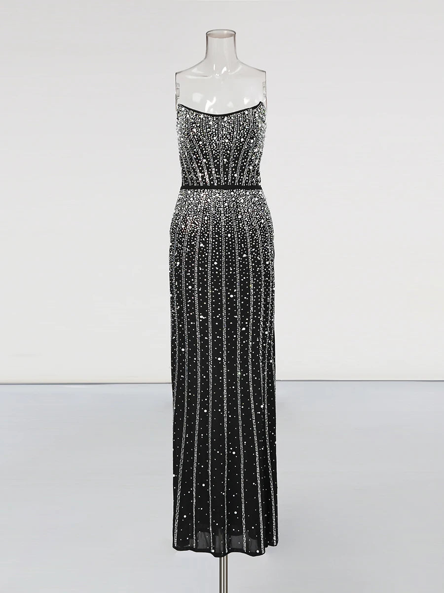 Black beaded evening gown on a mannequin against a white background