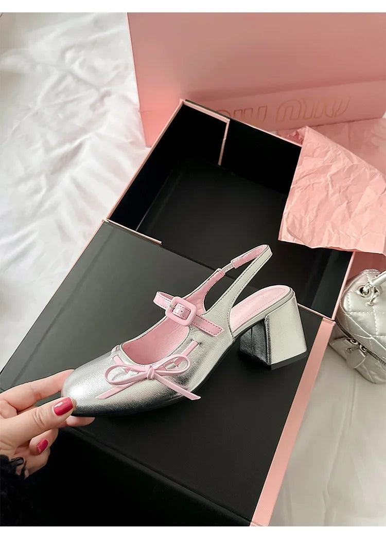 Silver patent leather chunky Mary Jane heel with pink trim and bowknot detail in a pink box.