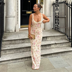 Woman in a floral dress standing on steps outside a building