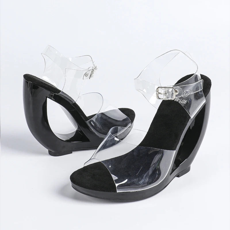 Black wedge sandals with clear straps on a white background