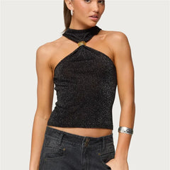 Woman wearing a black sparkly halter top against a plain background