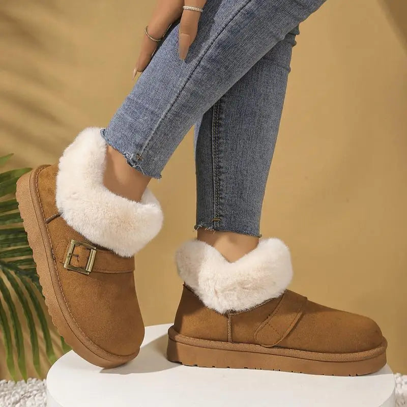 Brown suede boots with white fur trim worn with blue jeans on a beige background