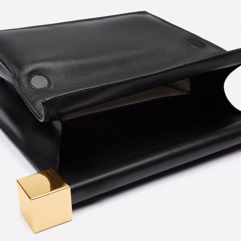 Black leather pouch with a gold clasp on a white background