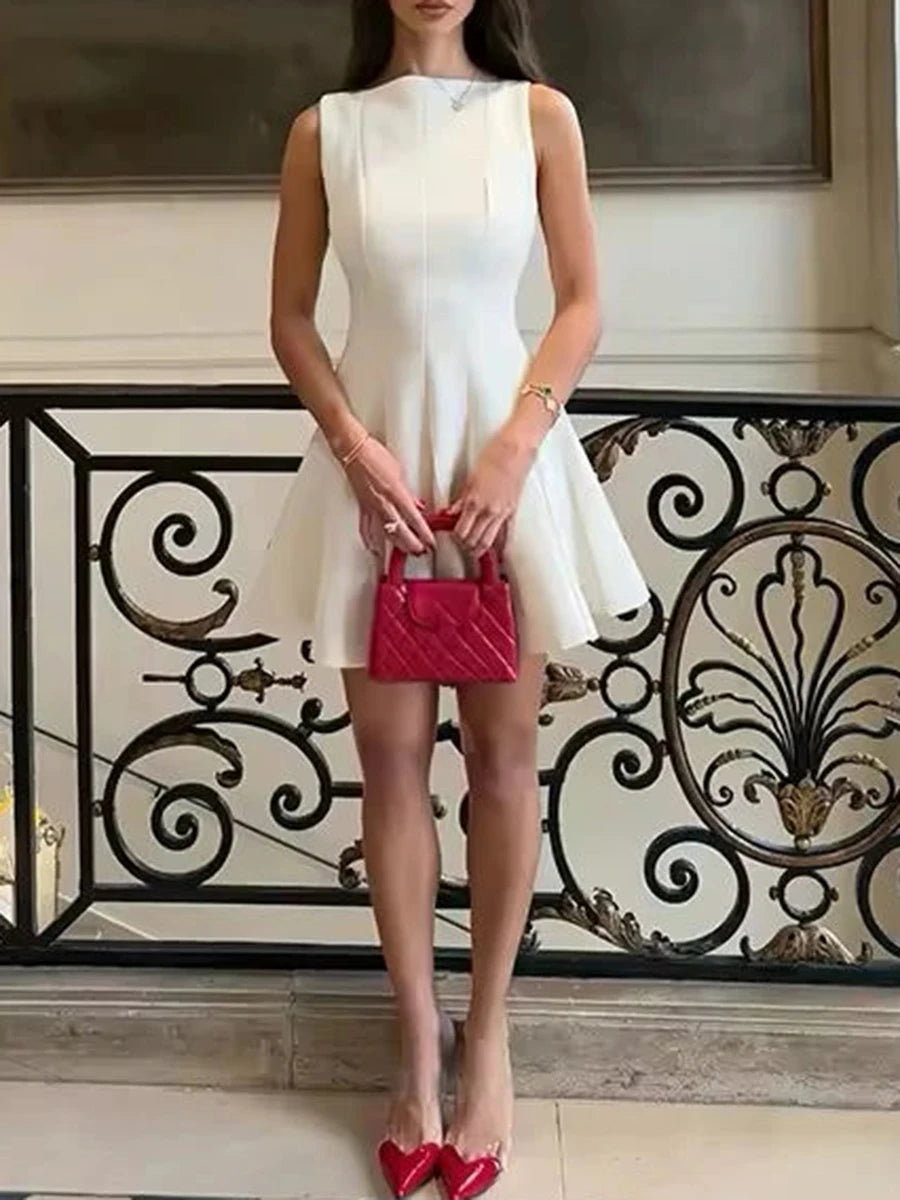 Woman in a white dress holding a red handbag in an elegant interior setting