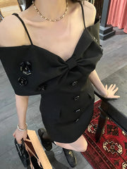 Black dress with a large bow detail worn by a person, sitting on a chair