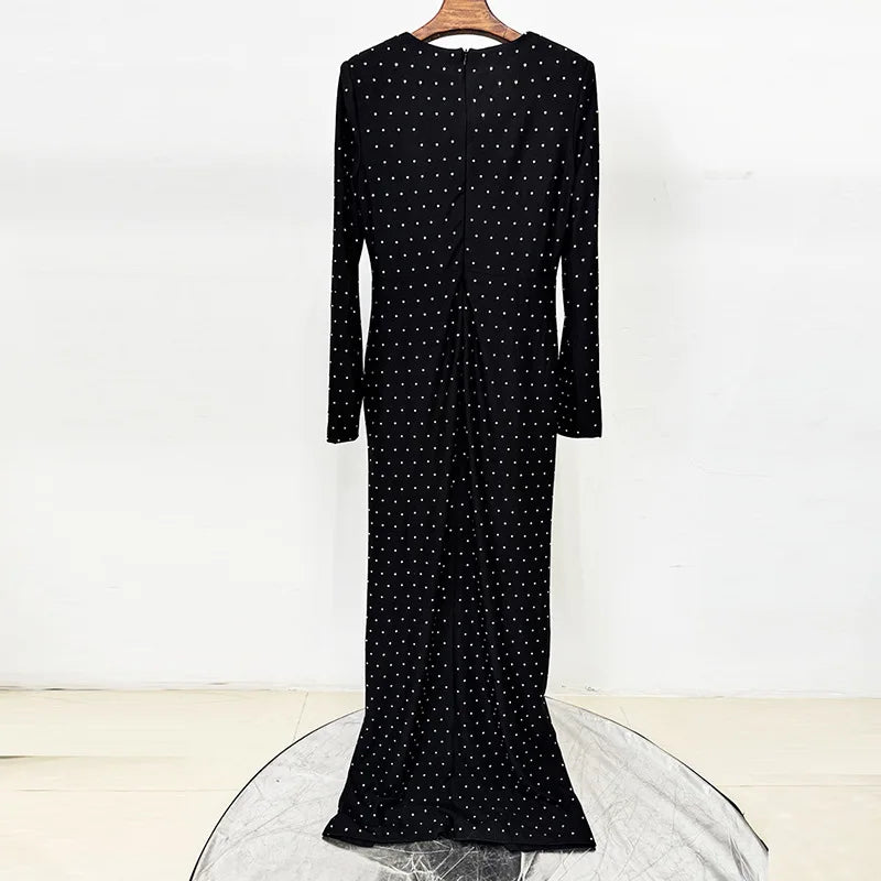 Black beaded polka dot maxi dress on a hanger, showing the back detail.