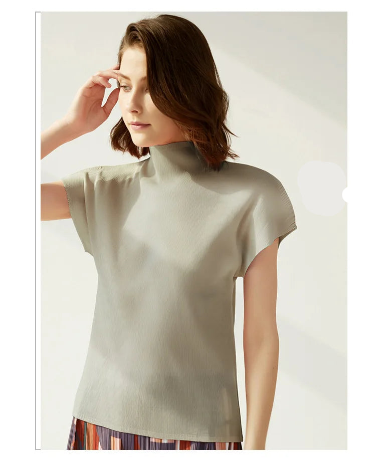 Woman wearing a light gray top with a plain background