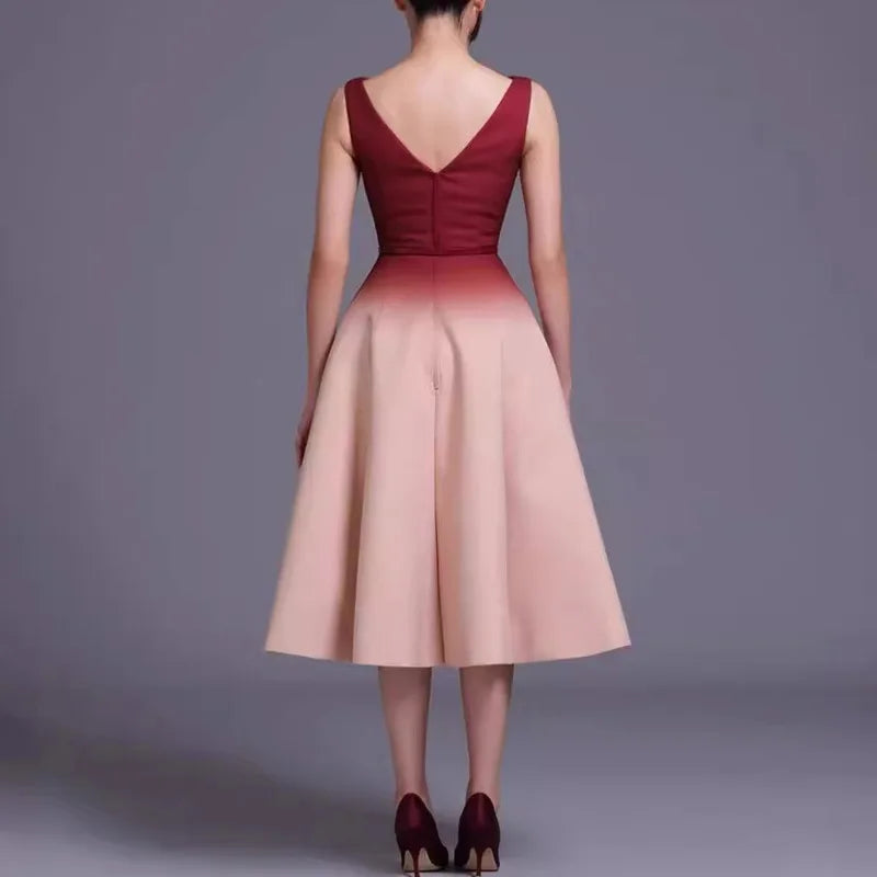 Woman wearing a two-tone dress with a gradient from red to pink on a gray background