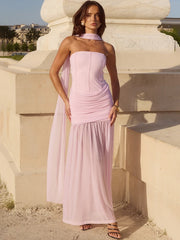 Woman in a pink dress standing against a classical architecture background