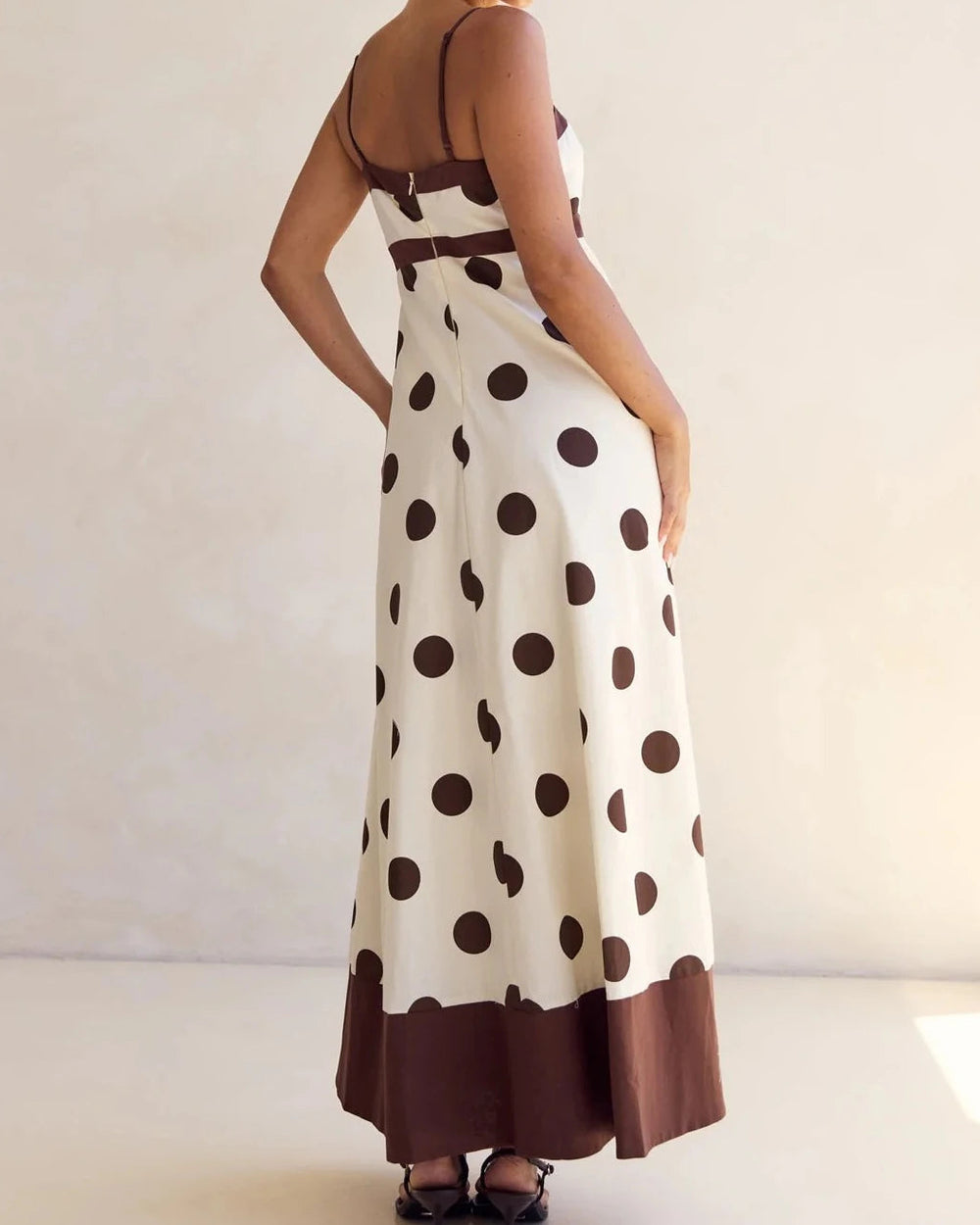 Woman wearing a polka dot dress with a plain background