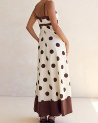 Woman wearing a polka dot dress with a plain background