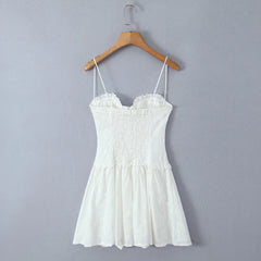 White dress on a wooden hanger against a gray background