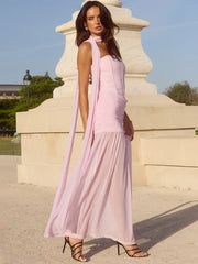 Woman in a pink dress standing in front of a classical statue