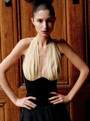 Woman wearing a black and white dress against a wooden background