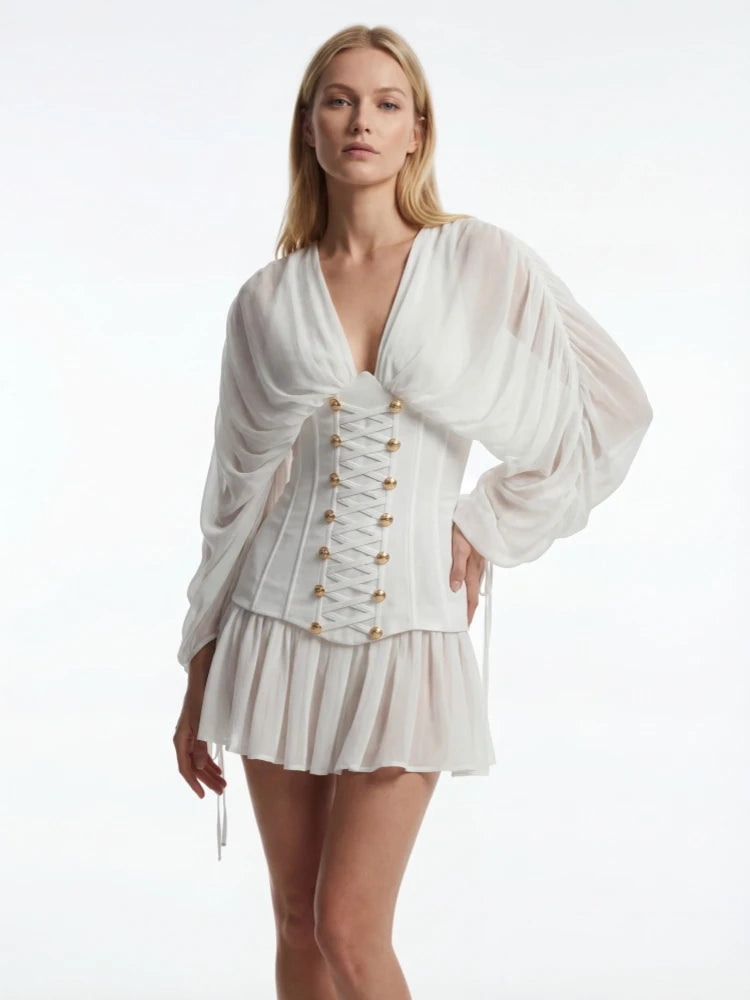 Woman wearing a white outfit with gold buttons on a white background