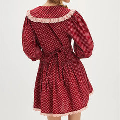 Red polka dot dress with lace trim on a white background