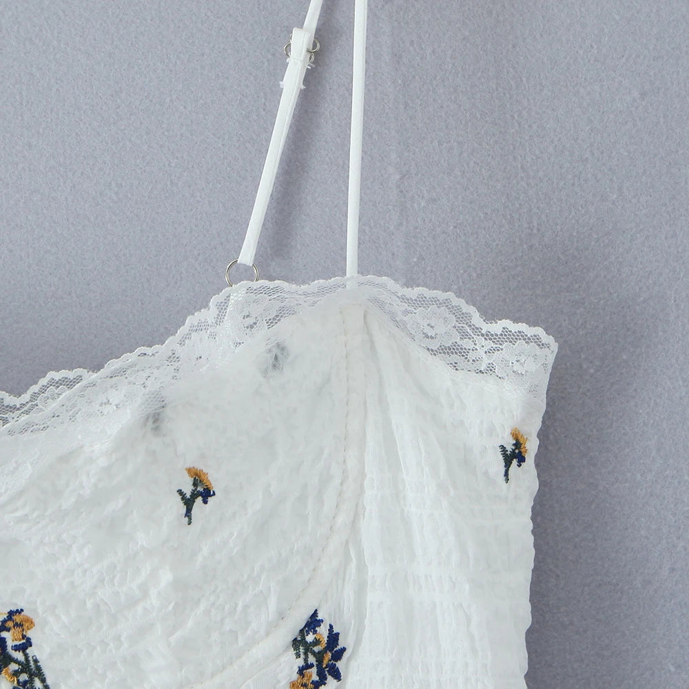 White lace garment with floral embroidery on a gray background