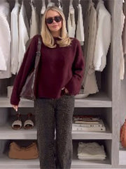 A woman wearing a solid-colored sweater paired with a trouser, showcasing its versatility and comfortable style.