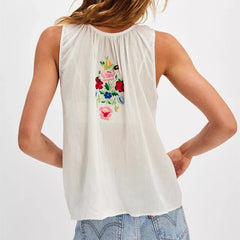 White sleeveless top with colorful floral embroidery on a plain background