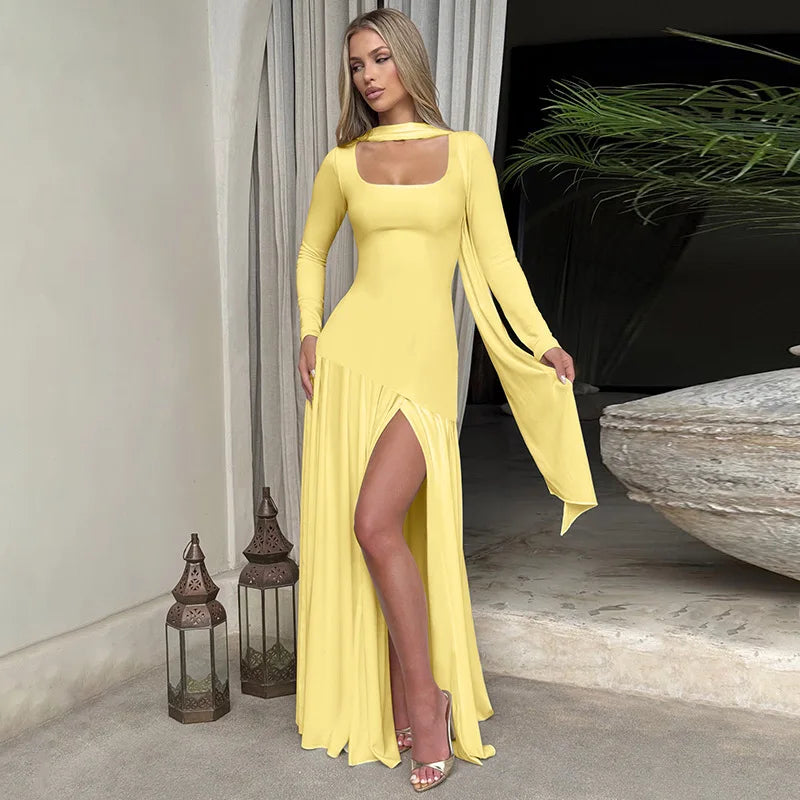 Woman in a yellow dress standing in an elegant indoor setting with lanterns and plants.