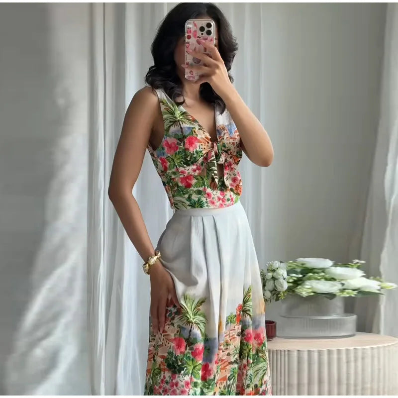 Woman in floral print V-neck sleeveless crop top and floral print pleated A-line midi skirt.