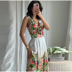 Woman in floral print V-neck sleeveless crop top and floral print pleated A-line midi skirt.