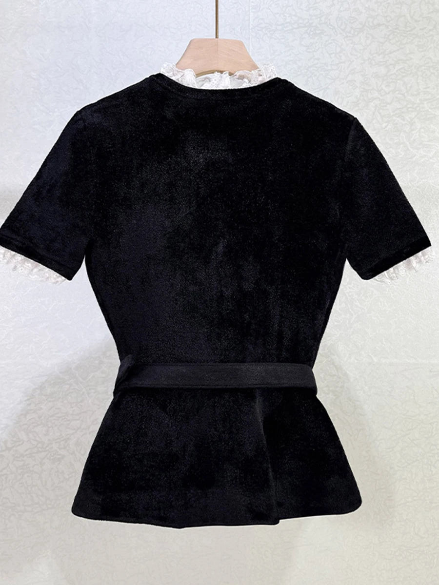 Black peplum top on a hanger against a white background