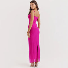 Woman wearing a bright pink evening gown with thin straps on a light gray background