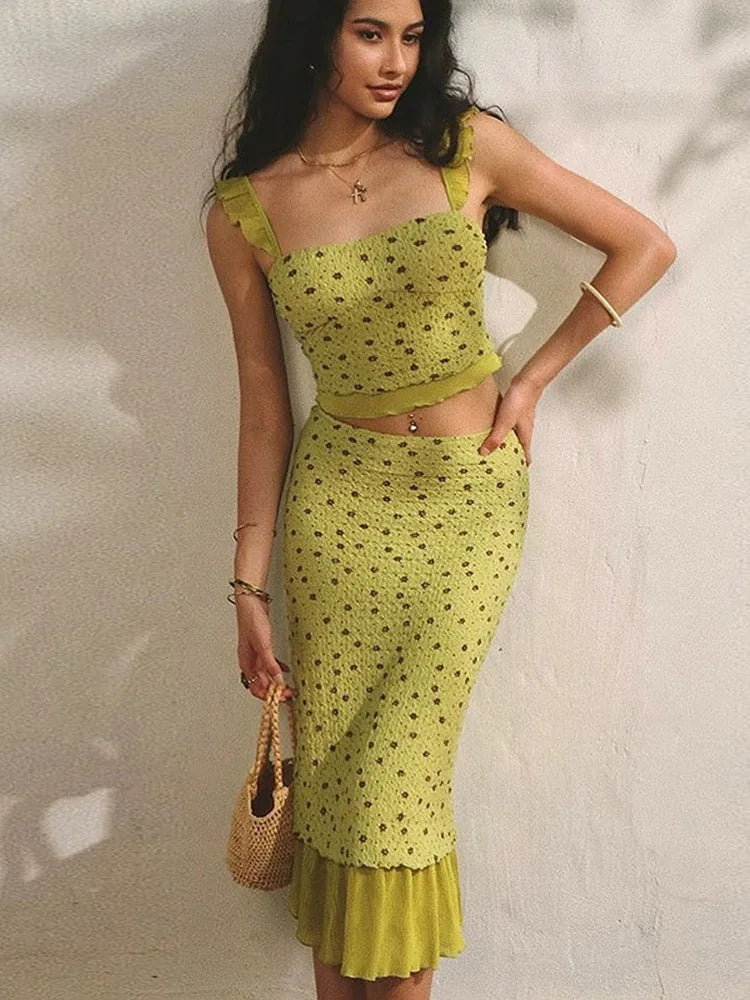 Woman wearing a green patterned outfit against a white wall