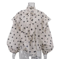 Polka dot blouse with ruffled collar on a mannequin against a white background