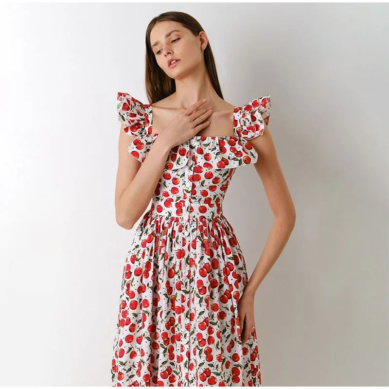Woman wearing a floral dress with red and white pattern on a plain background