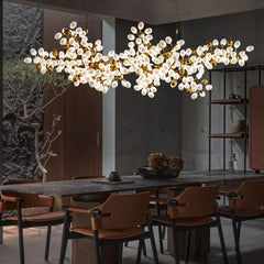 Modern dining room with a large chandelier, table, and chairs.