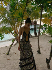 A model wearing a leopard print halter maxi dress with an open back, showcasing its glamorous style. Golden Atelier 2