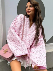 Close-up of a floral quilted kimono jacket on a model with a handbag