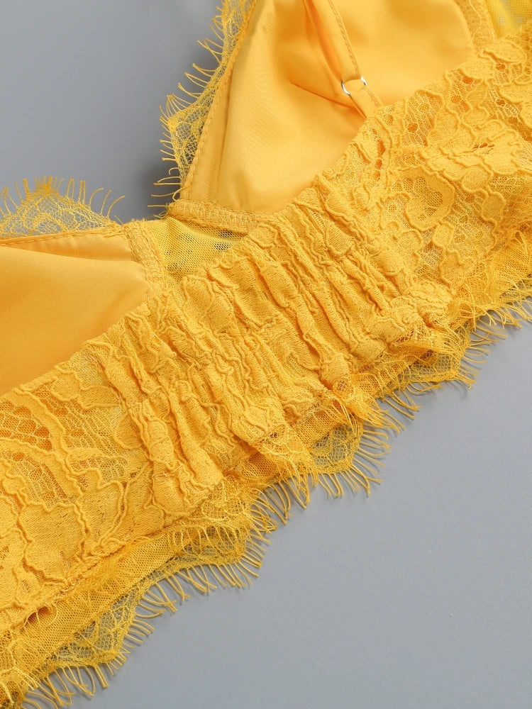 Yellow lace fabric with fringes on a gray background
