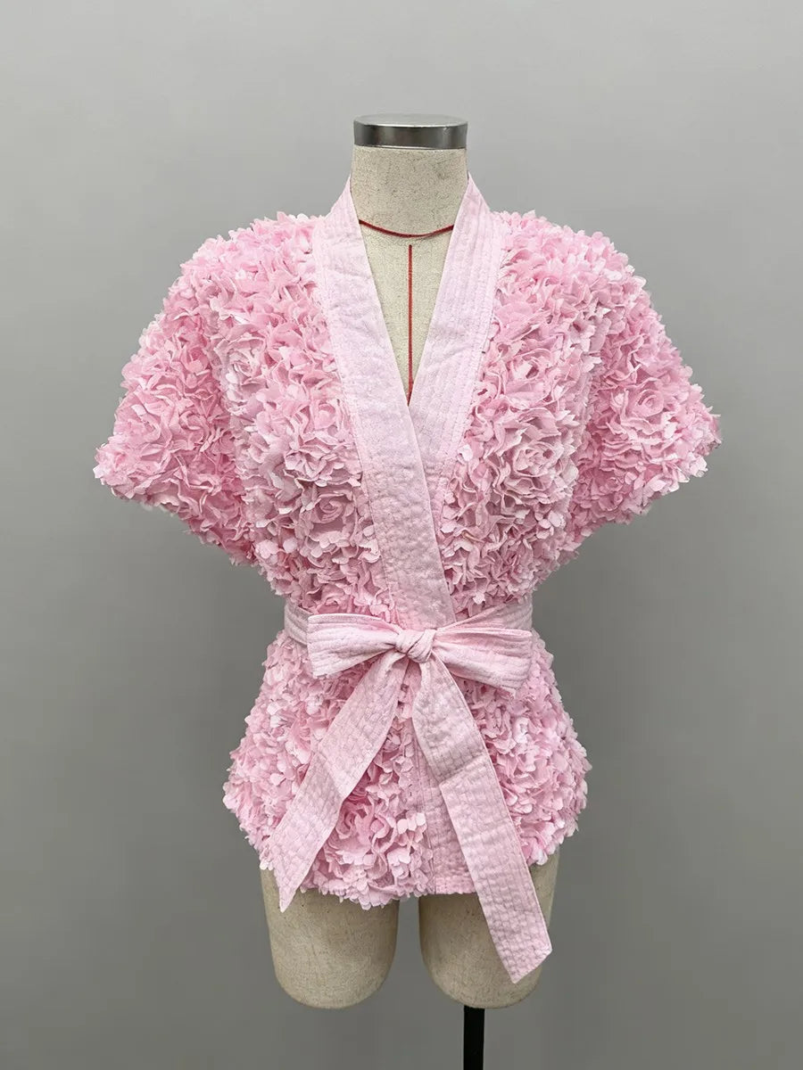 Pink textured dress on a mannequin against a gray background