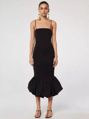 Black dress with ruffled hem on a white background